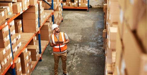 Nationwide network employee cataloging packages in warehouse.