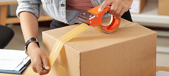 Customer taping a box to prepare for shipping